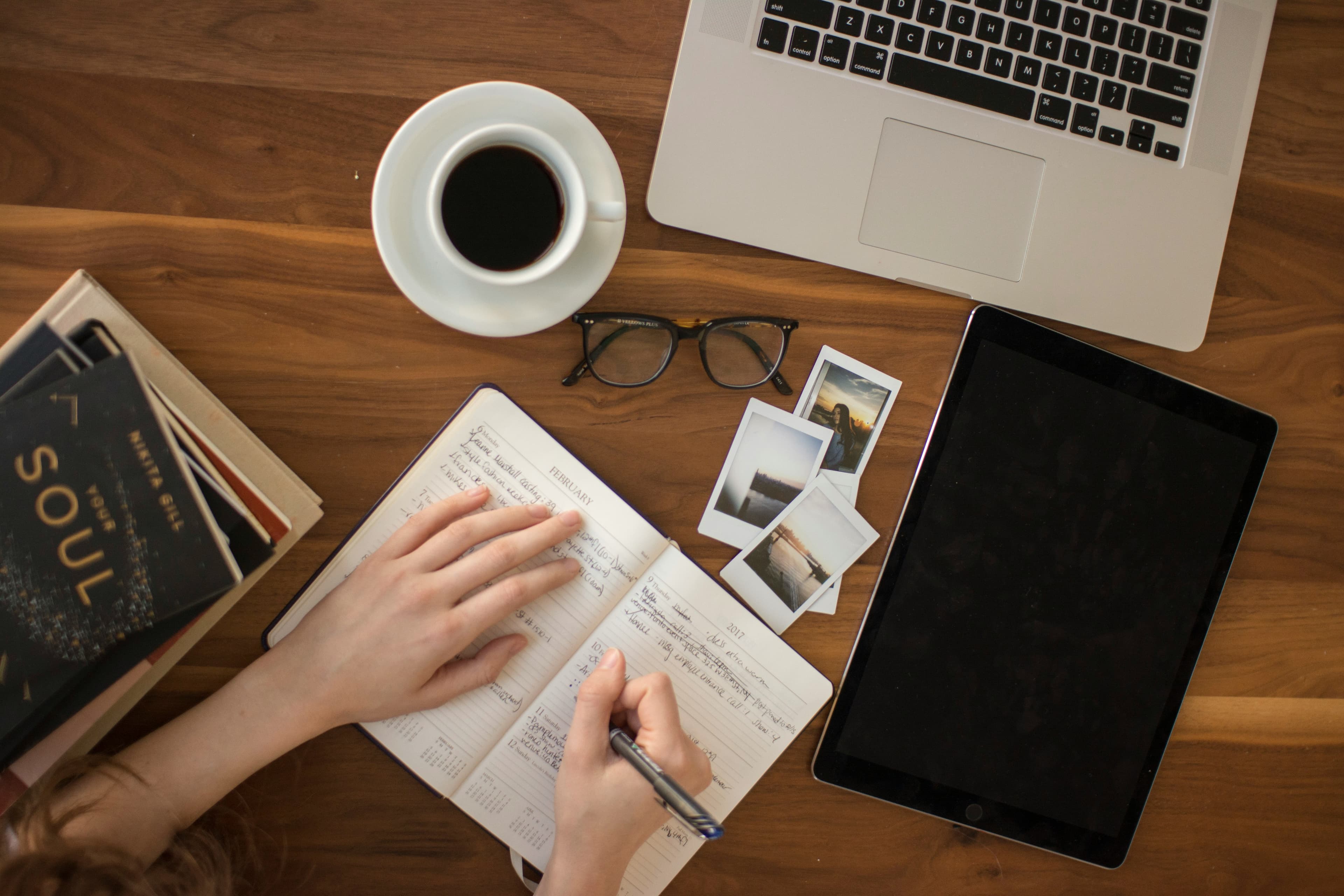 Notebook, laptop, and tablet arranged on a desk for writing practice